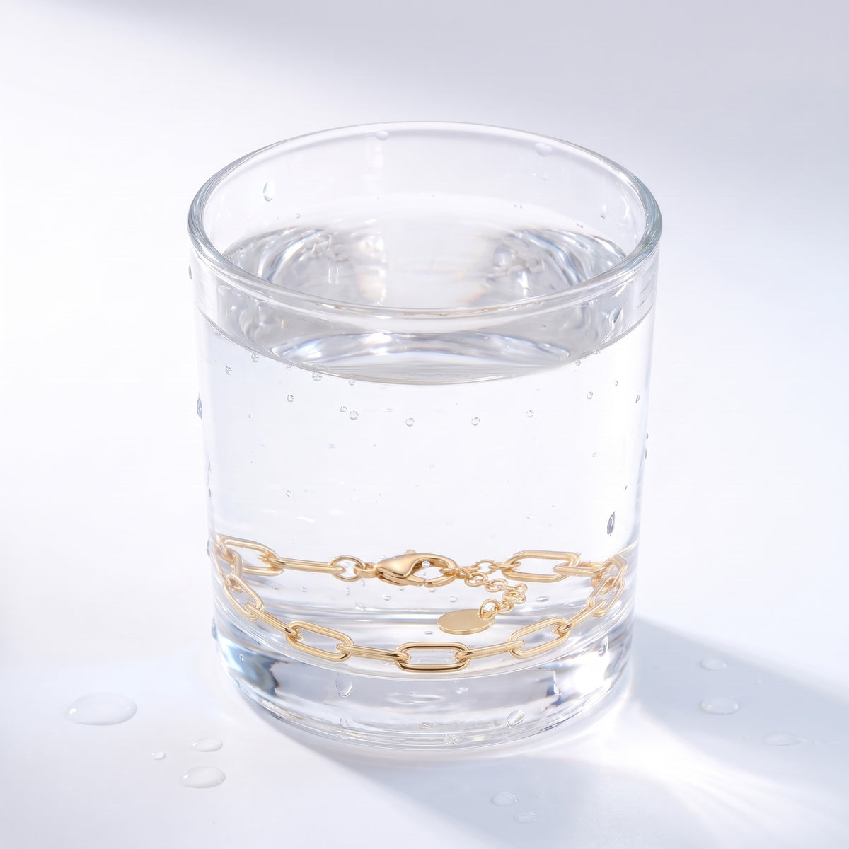 Bracciale a catena paperclip placcato oro 18K immerso nell'acqua