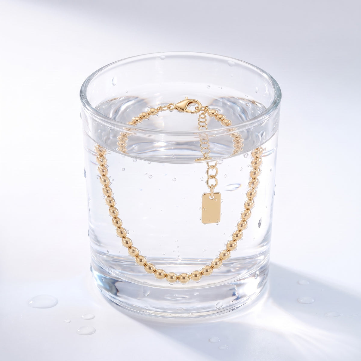 Bracciale a palline placcato oro 18K immerso nell'acqua