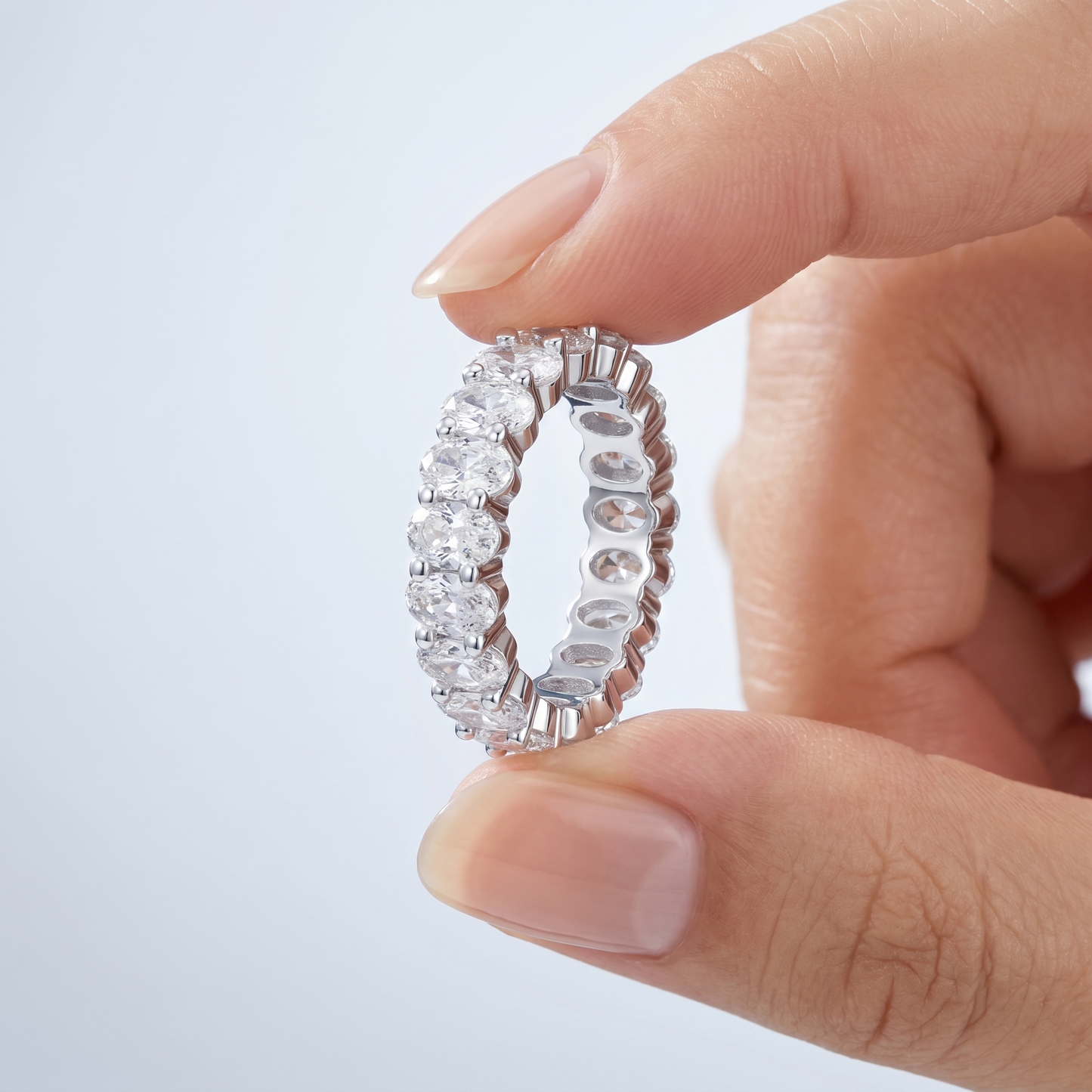 Anello Eternity Ovale CZ Oro 18K - scala reale tra le dita di una mano - UpperEast Jewels