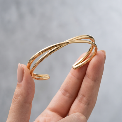 Bangle Rigido Crossover Oro 18K - scala reale tra le dita di una mano - UpperEast Jewels