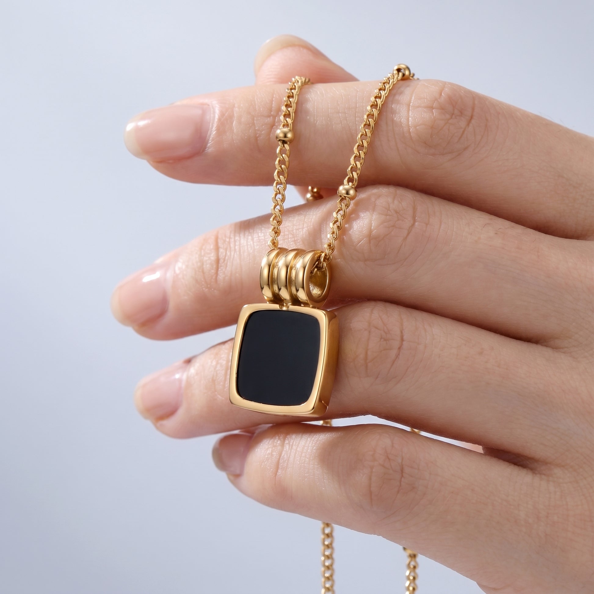Pendente Notte Conchiglia Nera Oro 18K - scala reale tra le dita di una mano - UpperEast Jewels