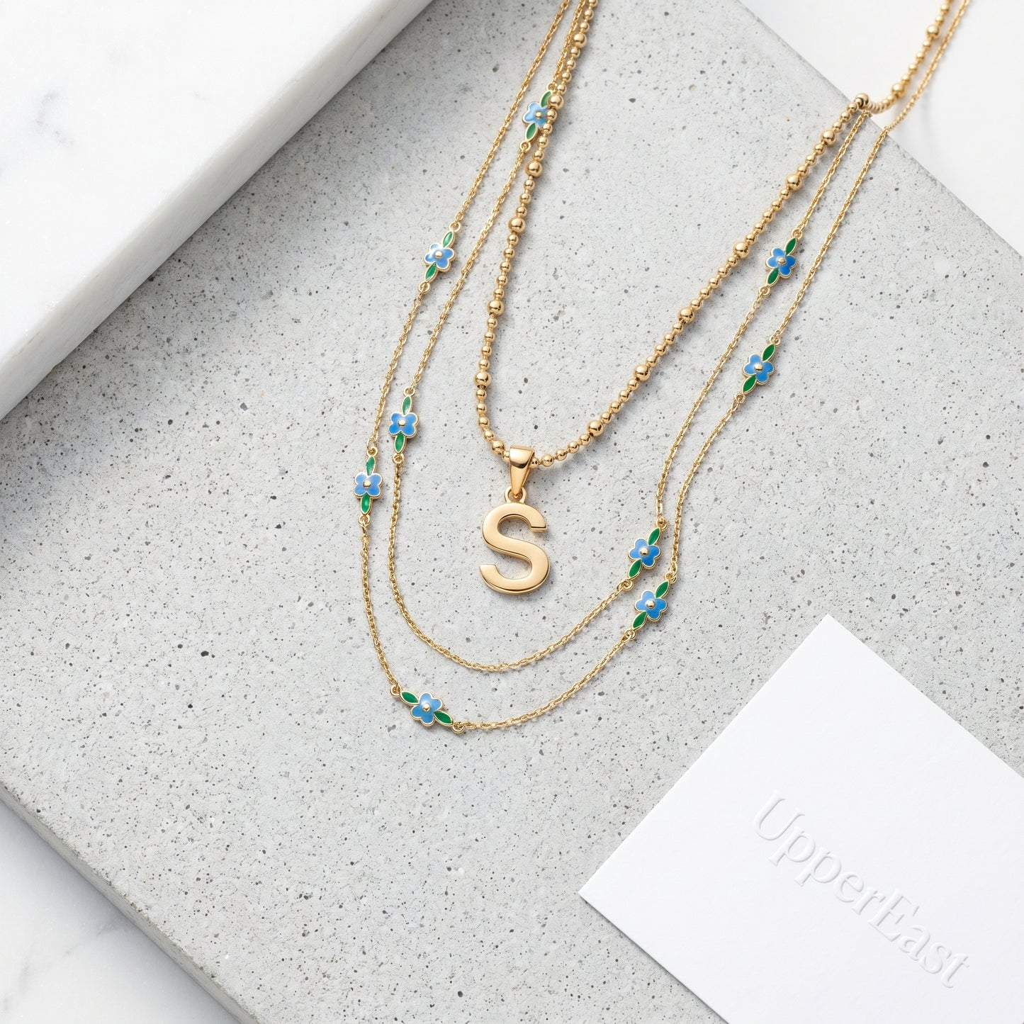 Collana Iniziale Lettera Oro 18K - flat lay con pezzi coordinati - UpperEast Jewels