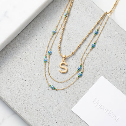 Collana Iniziale Lettera Oro 18K - flat lay con pezzi coordinati - UpperEast Jewels