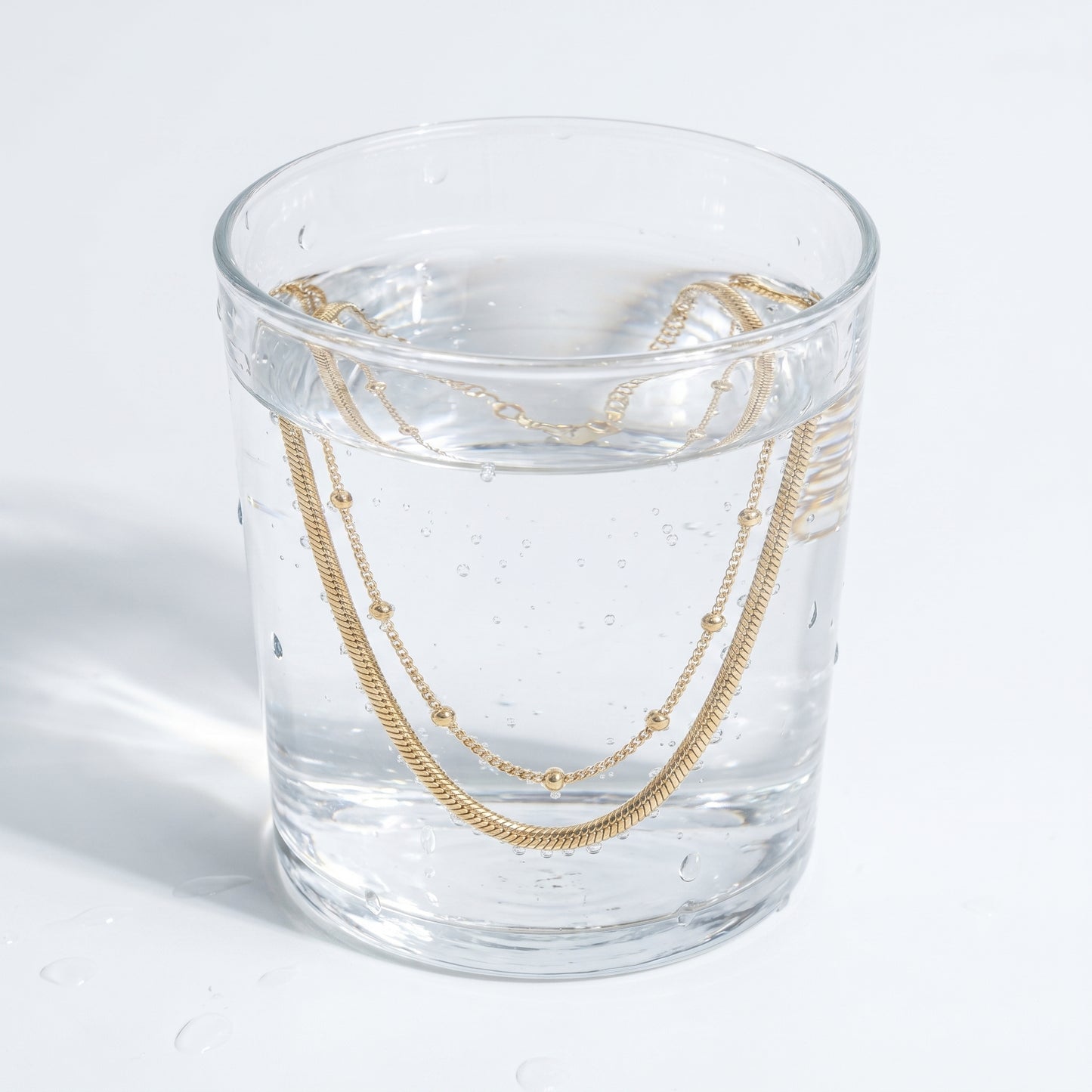 Cavigliera Layered Doppia Oro 18K - test waterproof in acqua - UpperEast Jewels