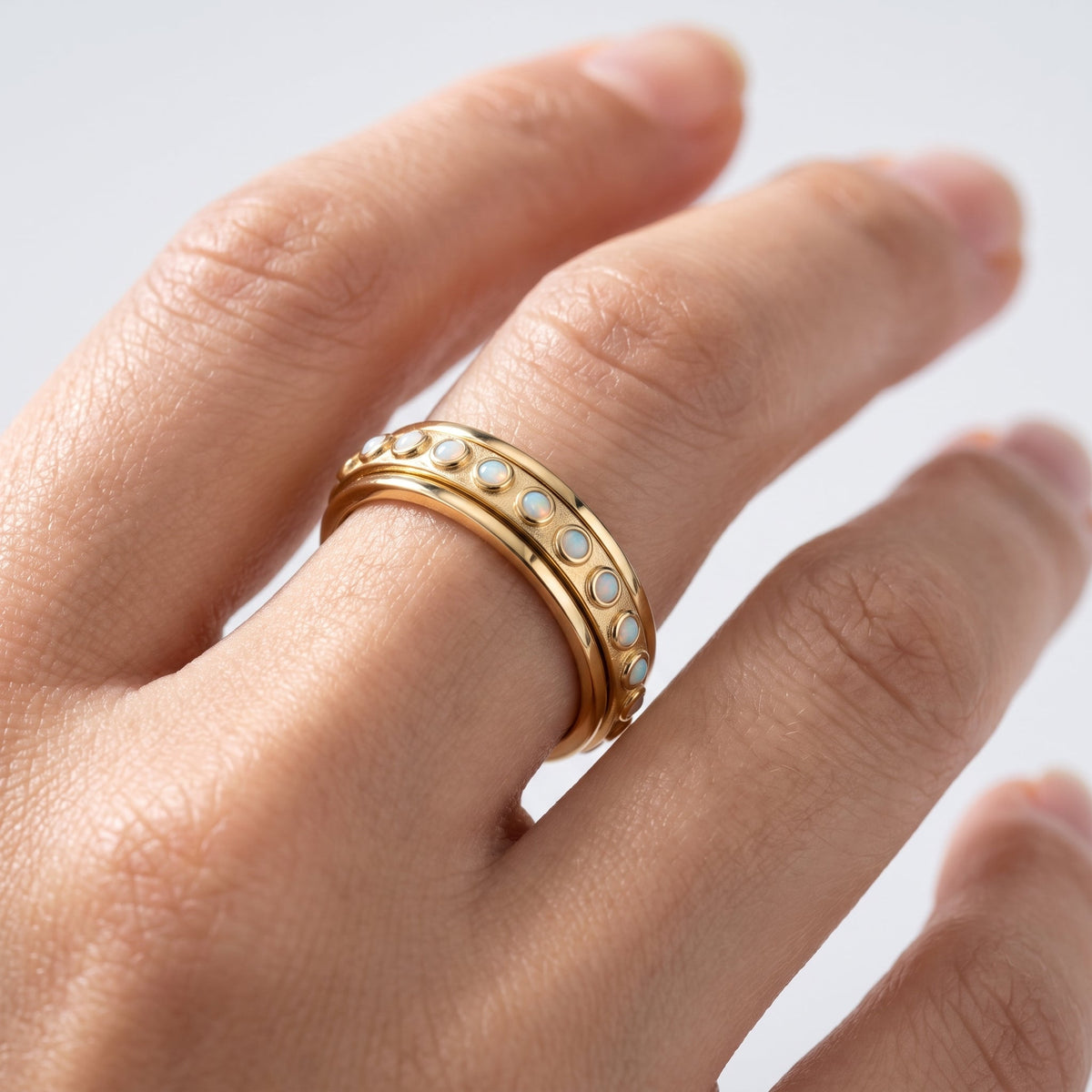 Anillo antiestrés giratorio bañado en oro de 18K puesto, primer plano