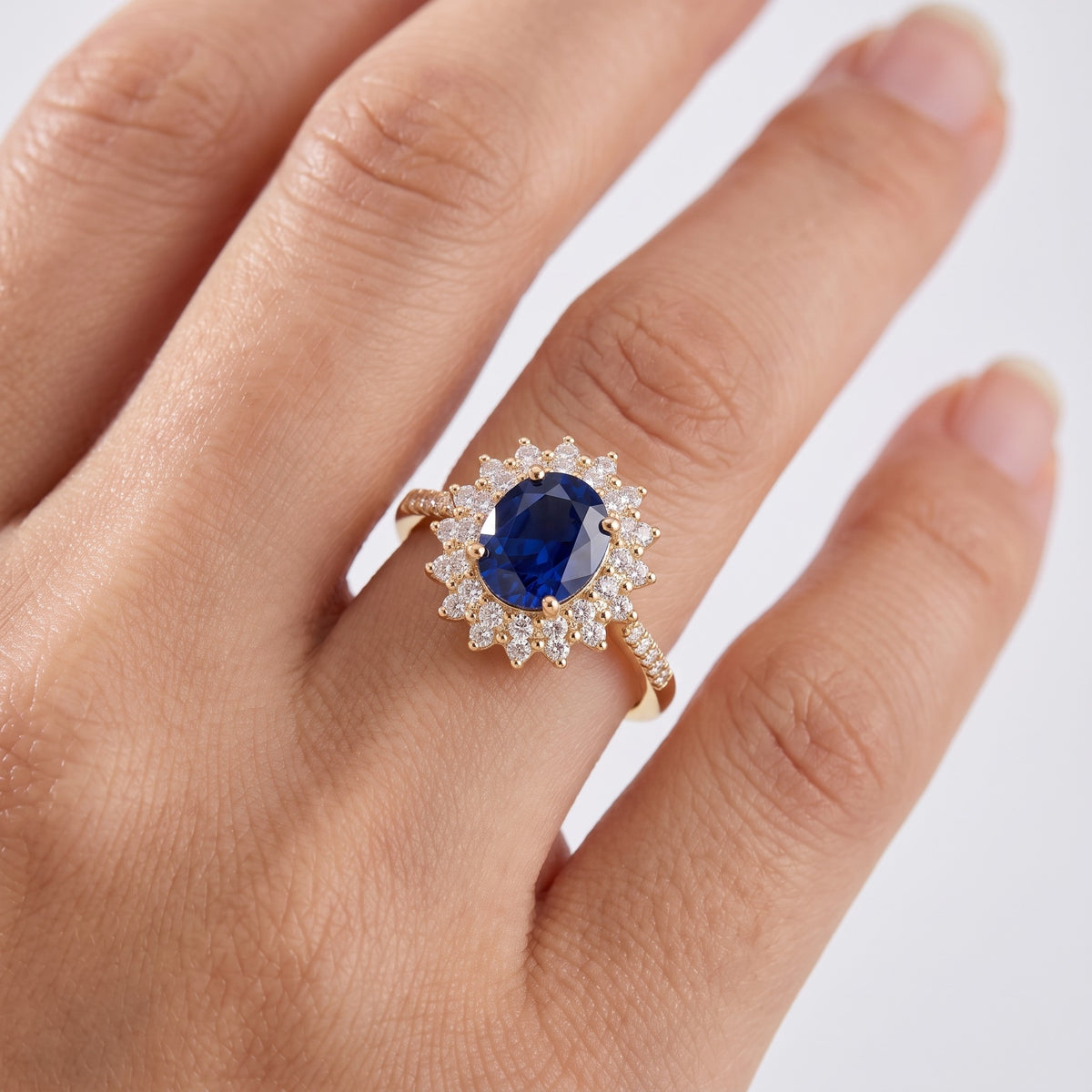 Anillo con piedra azul y circonitas bañado en oro de 18K puesto, primer plano