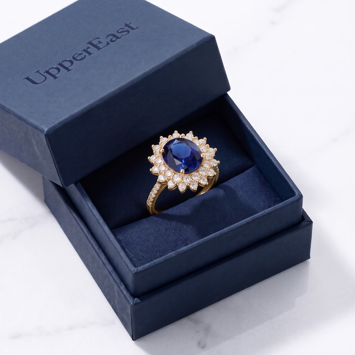 Anillo con piedra azul y circonitas bañado en oro de 18K en el estuche UpperEast