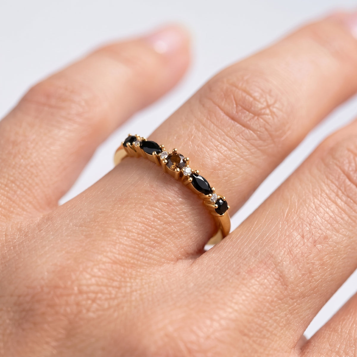 Anillo eternity de obsidiana negra bañado en oro de 18K puesto, primer plano