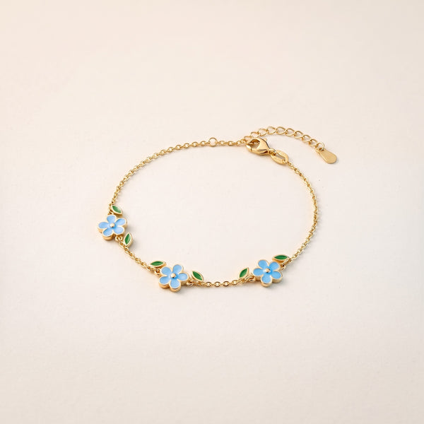Pulsera con flores azules bañada en oro de 18K