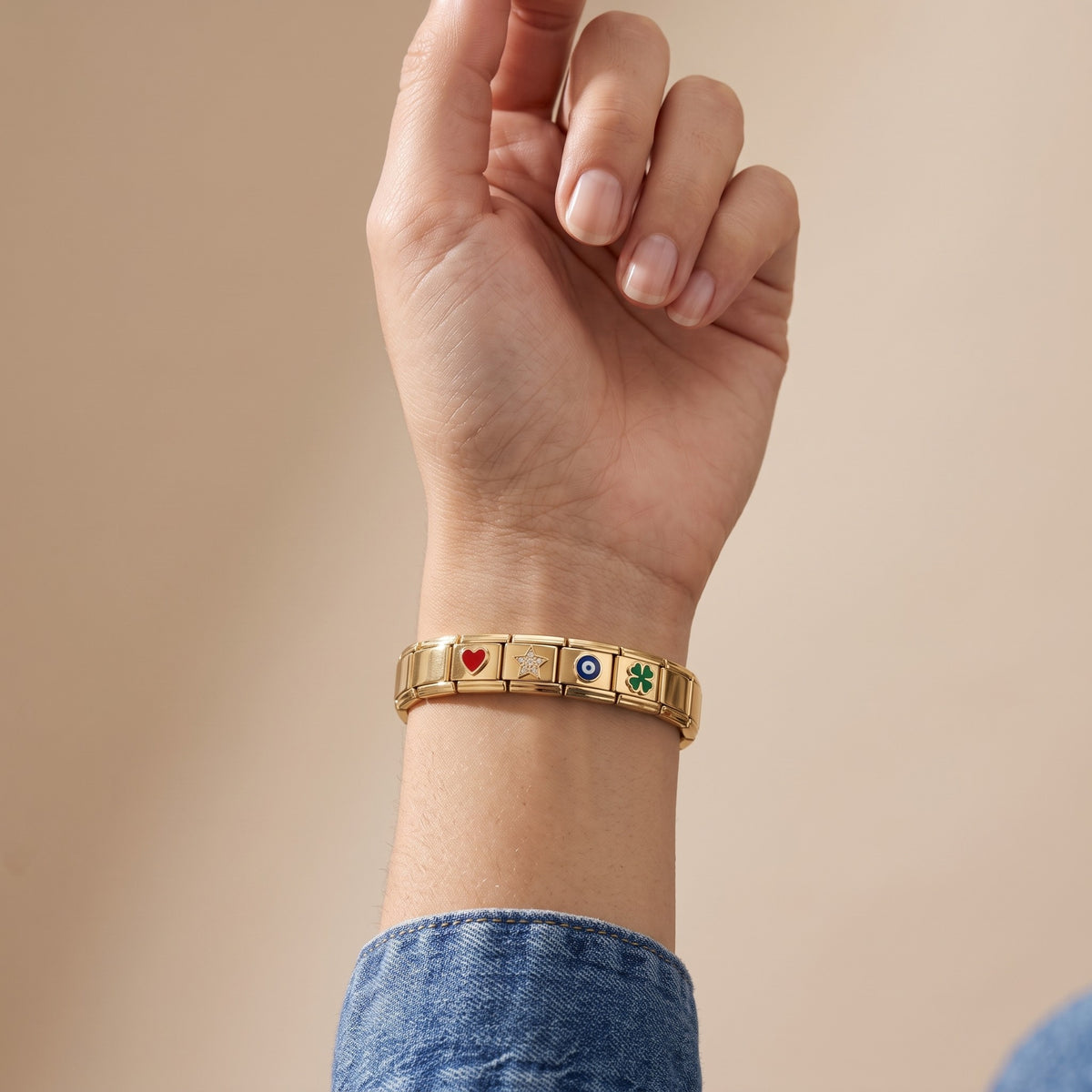 Bracciale componibile con charm placcato oro 18K indossato, primo piano