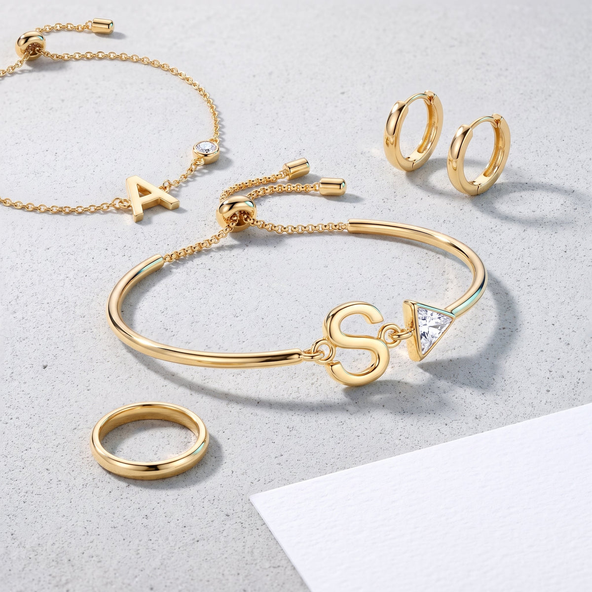 Bracciale iniziale e cristallo placcato oro 18K abbinato ad altri gioielli UpperEast