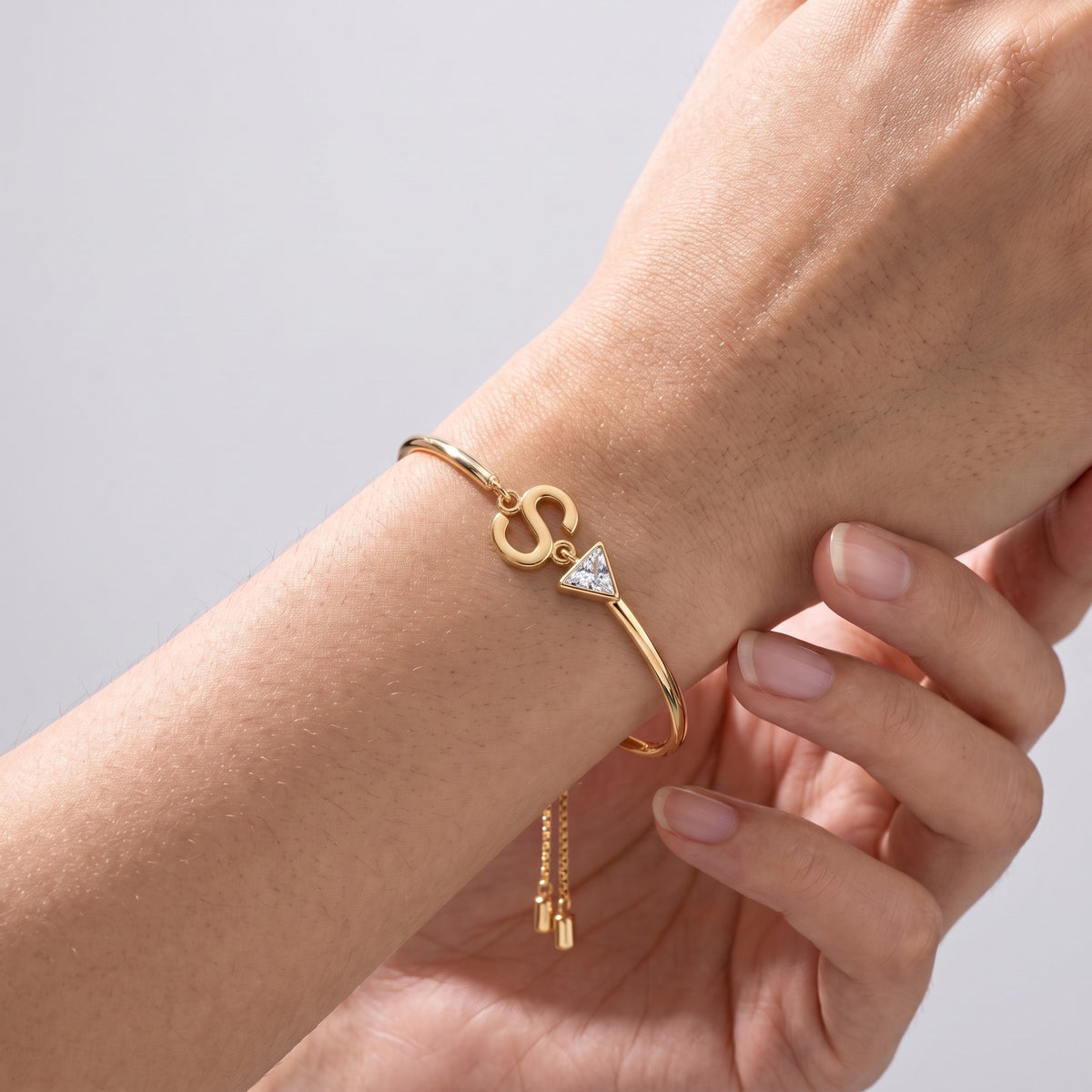 Bracciale iniziale e cristallo placcato oro 18K indossato, primo piano