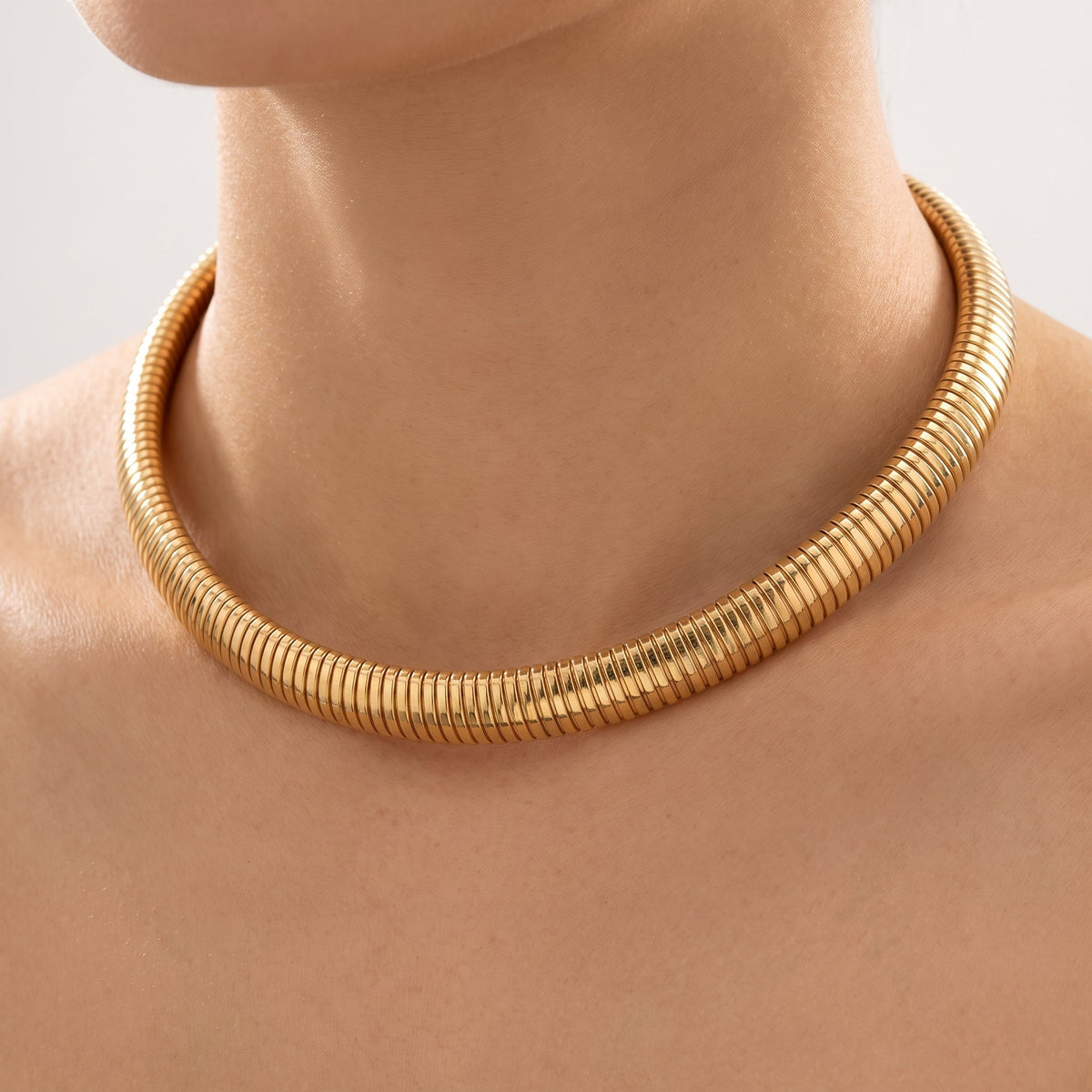 Collana girocollo tubogas placcata oro 18K indossata, primo piano