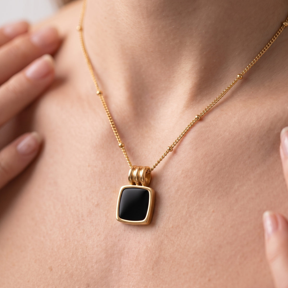 Collar con colgante de concha negra bañado en oro de 18K puesto, primer plano